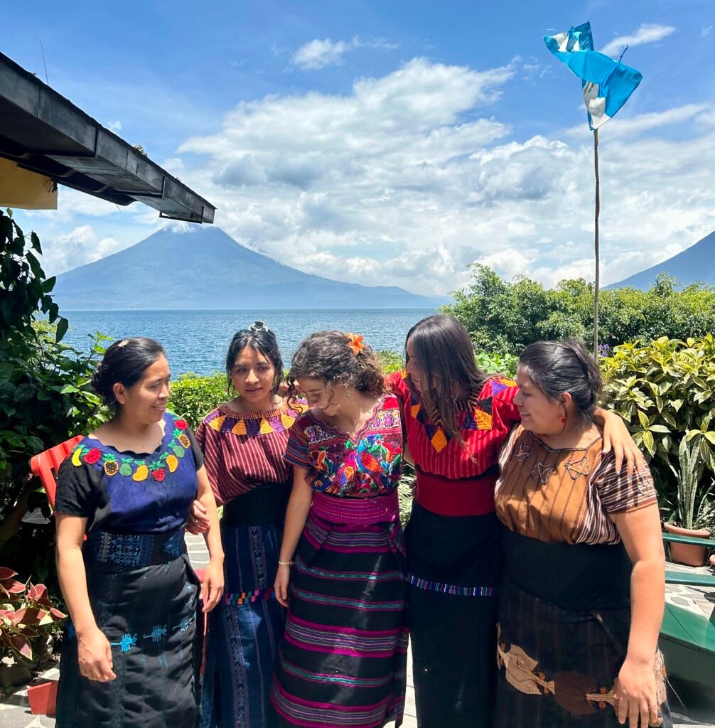 Travelers with local women in traditional dress by Lake Atitlán