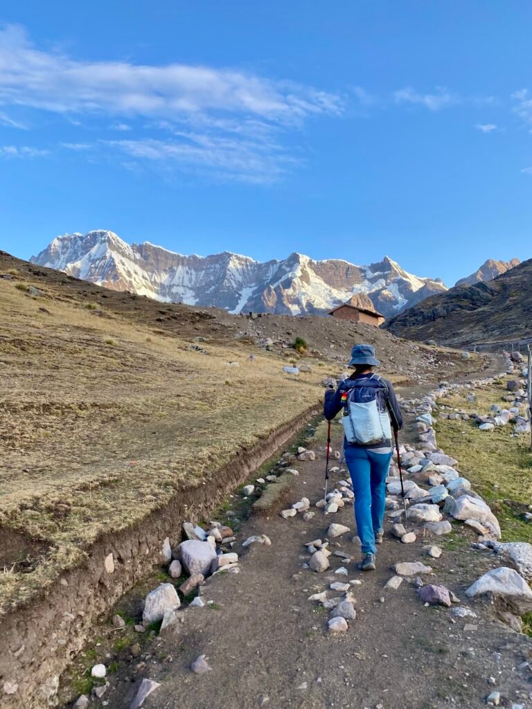 Hiker walking toward the snow-capped Ausangate range in Peru