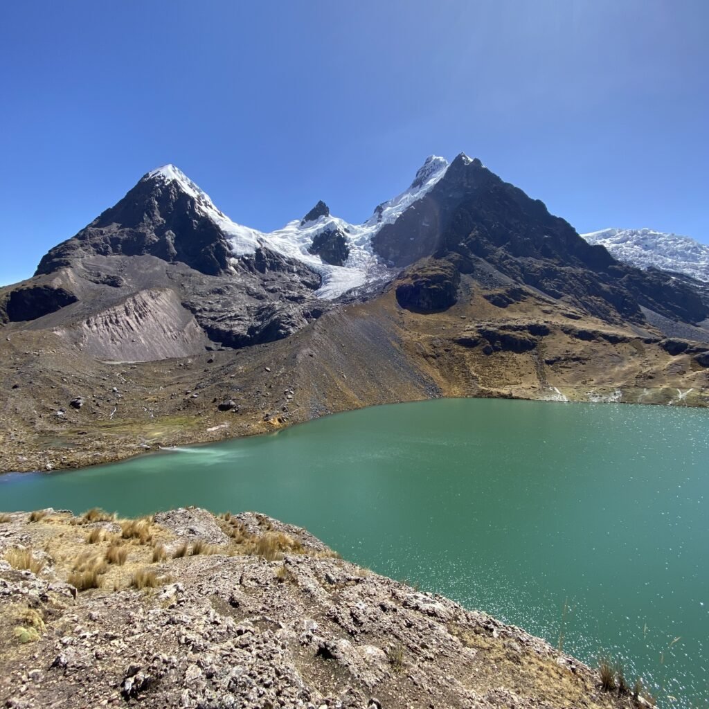 Glacial lagoon beneath snow-capped peaks in the Peruvian Andes